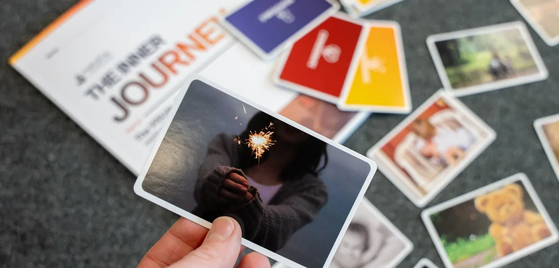 The Inner Journey workbook and a picture card held up over a spread of cards